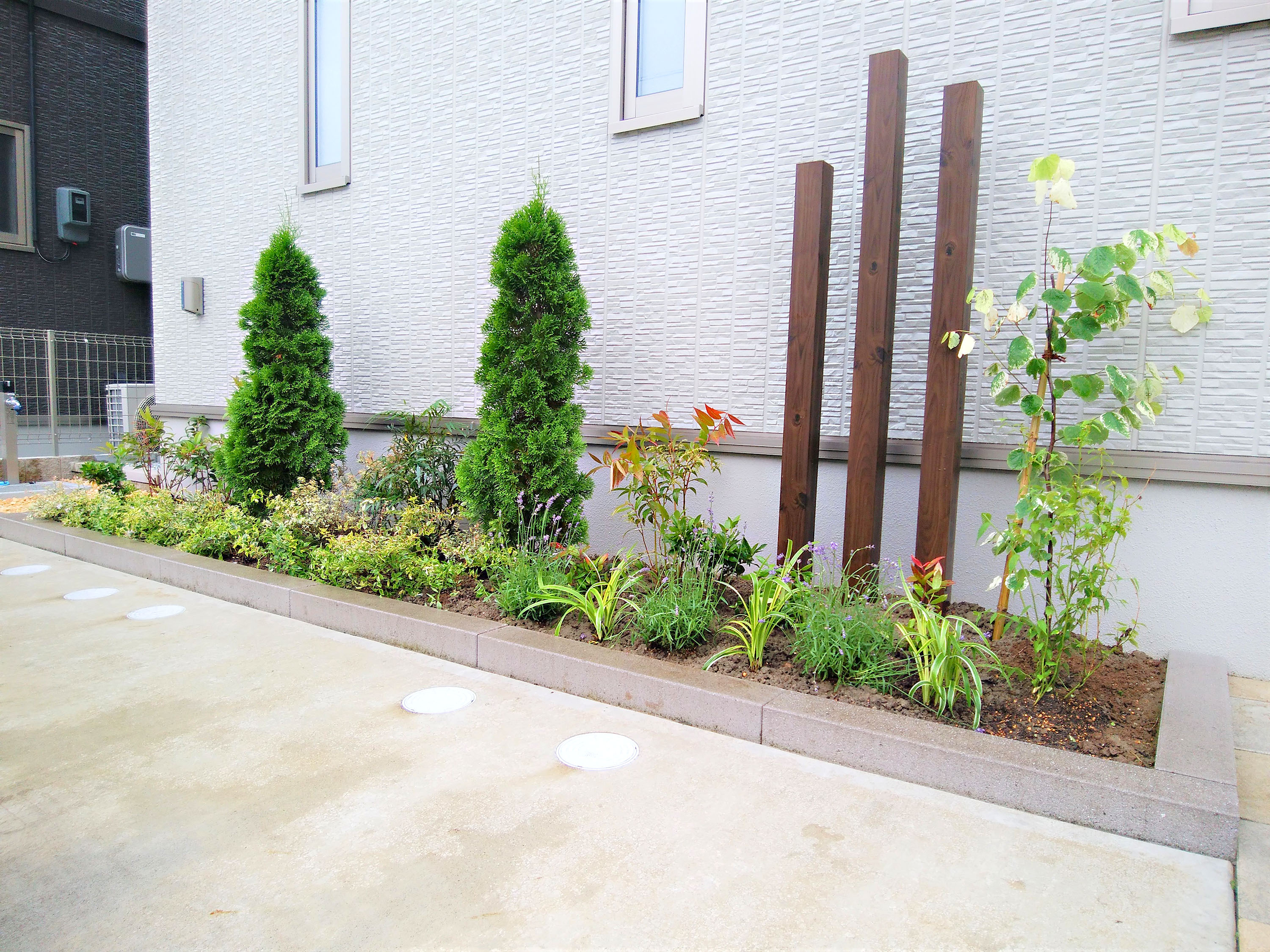 デザインブロックで作成したおしゃれなミニ花壇と市松模様のエントランス 株式会社エルヴェグリーン 株式会社エルヴェグリーン ガーデンプラット