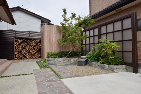 おしゃれな目隠しと薪ラックのあるお庭 有限会社海馬工苑 仙台利府営業所 Garden Gallery Oazon ガーデンプラット